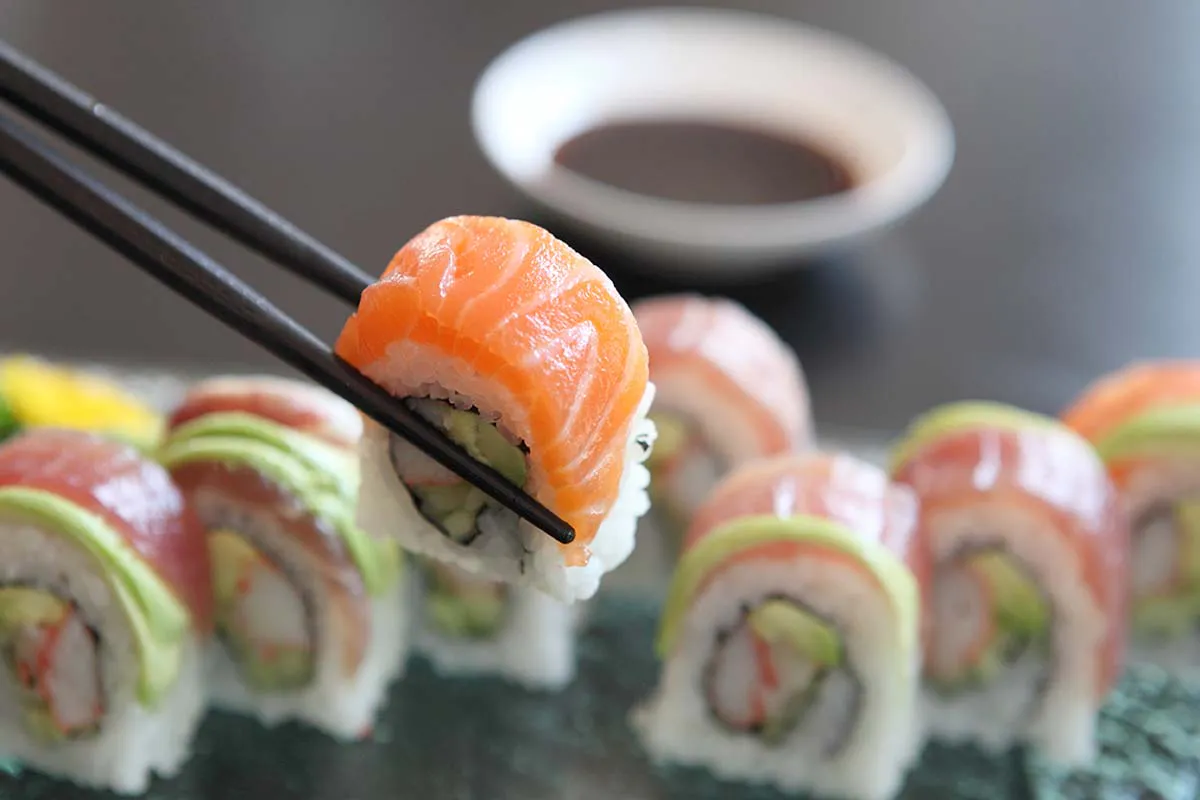 Chopsticks lifting salmon sushi roll at Yahao Asian Cuisine，an Asian Fusion Restaurant in Great Neck